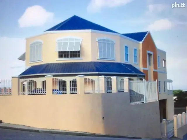 Three-storey cream office building with blue roof in San Fernando
